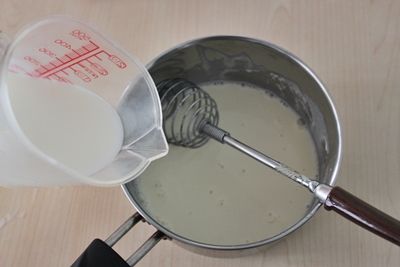 [起司醬汁]將牛奶半杯用左手一點點倒入，右側手持續攪動，直接到攪拌均勻。
