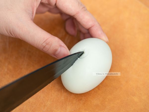 鹹蛋先敲裂一個洞後，用刀切對半