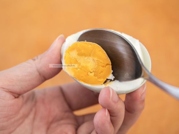 用湯匙挖出兩顆鹹蛋的蛋黃