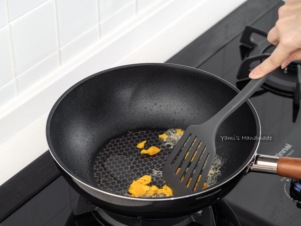 鍋中再放入一大匙油，放入鹹蛋黃開始攪拌