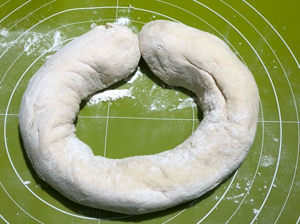 從麵糰中間挖一個洞，拉成粗細一致的條狀，然後從任一處分開。