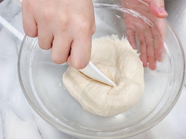 用飯匙將麵糰從底部刮起來、由外往內壓拌一下，麵糰表面就會變得很光滑。

註：這個步驟也可以灑點麵粉防沾，用手將麵糰揉至光滑。