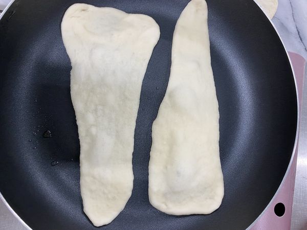 將瓦斯爐開到小小的「米粒火」，將擀好的餅下鍋乾烙
第一面烙到像圖片這樣起泡，就可以翻面。

註：米粒火就是瓦斯爐的旋轉扭對在11點鐘方向，火焰不是爐心火，是週圍一圈的小小火喔。