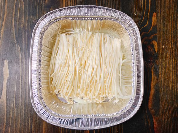 錫盒放入洋蔥絲，再擺上金針菇