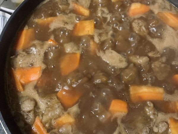 以熱水將咖哩塊化開，加入鍋中均勻攪拌，加入紅酒小火煮約 10 分鐘