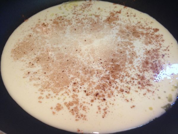 1小匙奶油熱平底鍋，加入兩大湯匙的麵糊，左右輕輕轉動鍋子讓麵糊平均散佈成薄薄的圓形，上頭灑上肉桂粉，小火慢煎。