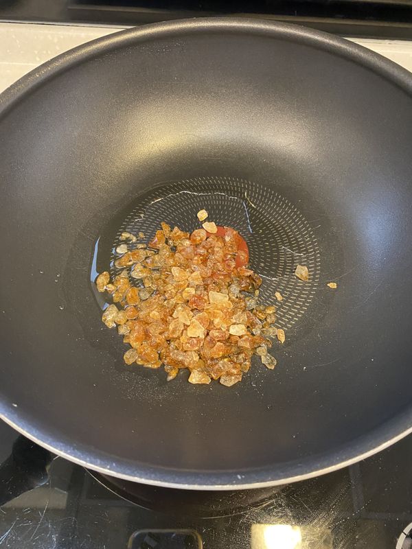 然後開始炒糖色，在鍋中倒入少許油，並放入冰糖，用小火不斷拌炒（炒的過程中不能心急，火候要維持小火～）