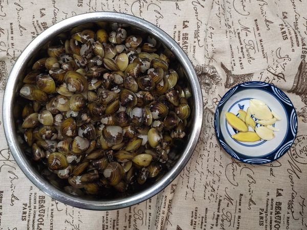 1.蜆仔清洗時可以像洗米一樣搓洗，洗淨後挑斂一下開口的、浮在水面上的都丟棄不用。
2.薑切片，蒜頭拍打一下或是切片。