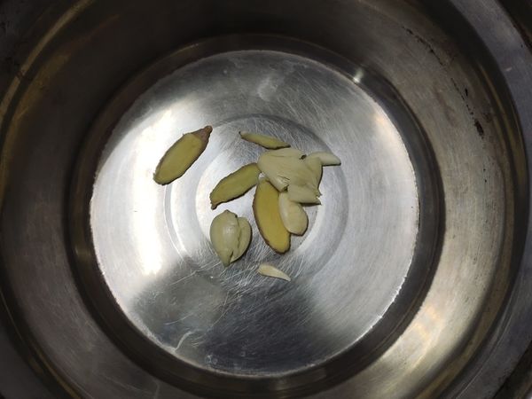 選一個不鏽鋼鍋底部平整為好，放入蒜頭薑片去蜆的腥味。