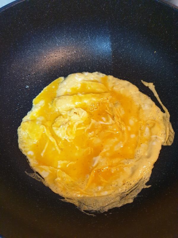 油燒熱後，蛋液入鍋攪拌