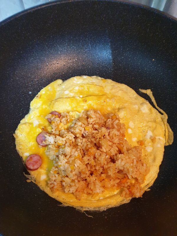 趁蛋液未凝固時，擺入炒飯(擺在中間或側邊)