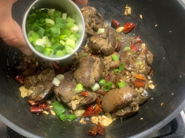 鍋內油，炒香花椒、乾辣椒、蒜末，再放入雞肝拌炒後，撒上胡椒鹽、蔥花拌勻即可