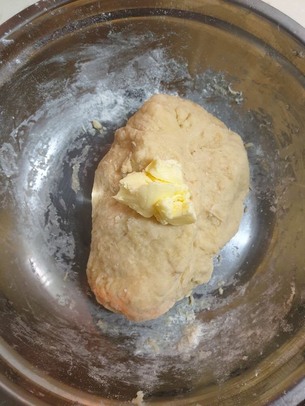 把軟化的奶油分3次揉入麵團中，此步驟請耐心揉麵6~8分鐘