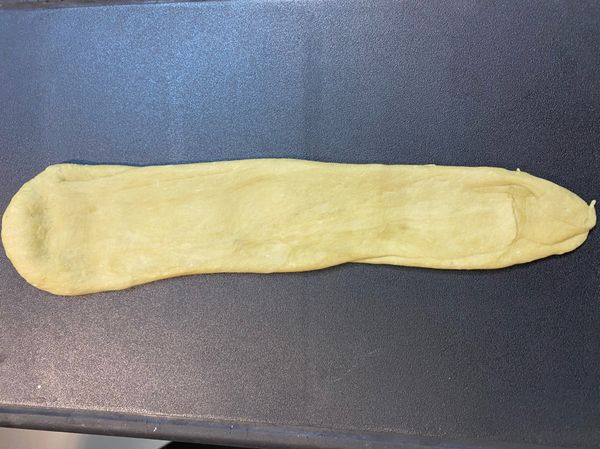 將麵糰切成6份，並搓成細長條，橄平（至少中型砧板長度）