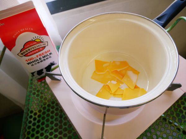 鍋中放入起士片及鮮乳煮至融化。