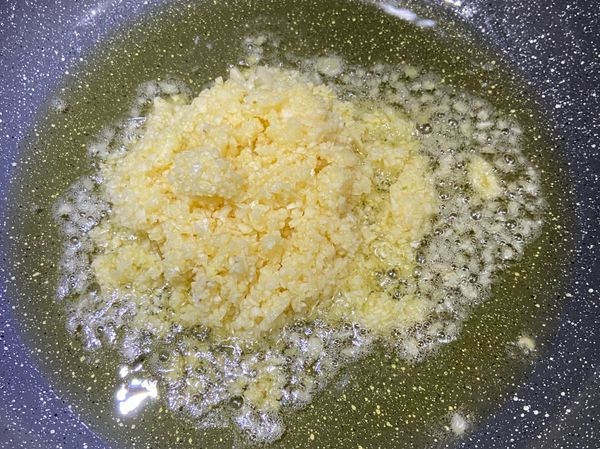 倒入食用油後，冷油下蒜末及薑末