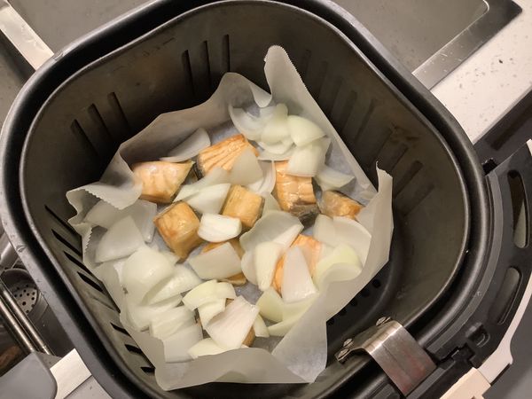 氣炸鍋鋪上烘焙紙，放入鮭魚塊200度烤15分鐘；
然後將洋蔥塊分成一瓣一瓣，180度再烤10分鐘。