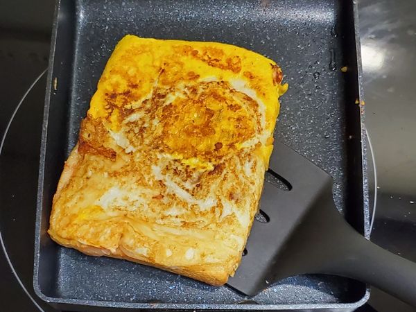 完成貼合後，再重新翻面，讓吐司夾心中的餡料熟透，若只是簡單只加蕃茄醬及起司，就不用特別再翻面，直接起鍋就能食用了。