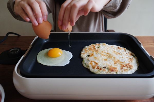 兩面餅皮煎上色後，打蛋下鍋
