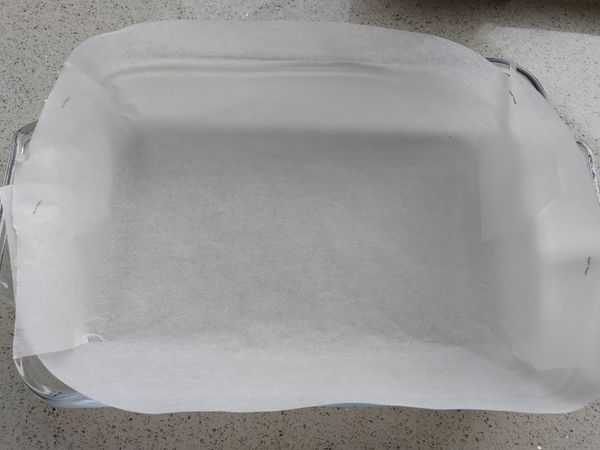 把烘焙紙放入烤模 摺成四方形後用訂書機訂好