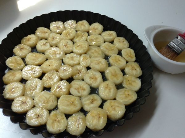 將香蕉切片並兩面都刷上蜂蜜檸檬液(一顆檸檬水+蜂蜜調勻)後，排在事先塗好一層薄薄奶油的派模上。(我用的是10"的)