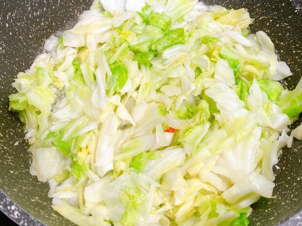 接著加入高麗菜拌炒，加入少許鹽及水，蓋上鍋蓋燜煮一下，再加入鮮味炒手及一點胡椒粉，即可美味上桌。