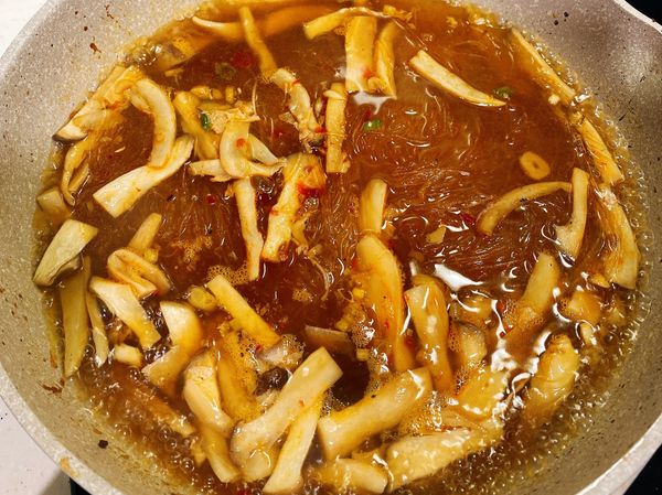 接著倒入約600-700mal的水，煮至微滾後，加入事先泡水軟化的冬粉，蓋上鍋蓋燜煮約2分鐘。