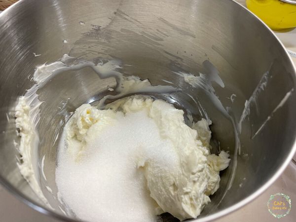 將軟化的奶油乳酪用電動攪拌機打散，倒入全部的砂糖並攪打均勻。