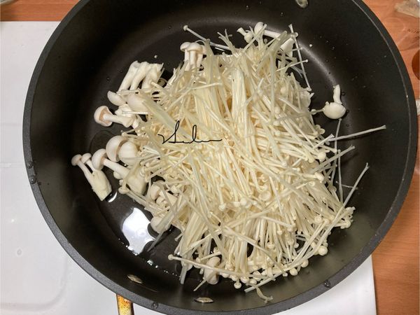 中火，倒入沙拉油後放入洗好的雪白菇和金針菇。