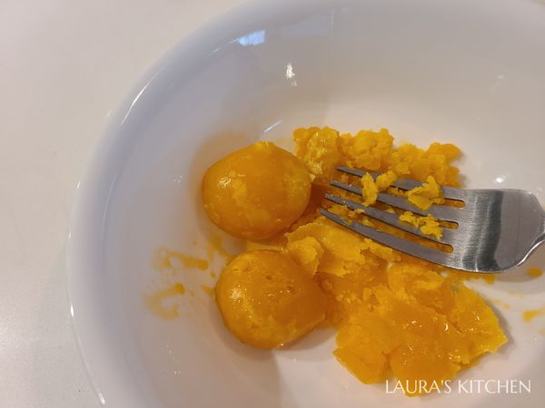 把鹹蛋黃蒸熟或烤熟，用叉子先壓碎，再用細網子過篩