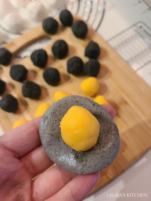 把小麵糰壓扁，包入一顆冰硬的餡，捏緊收口