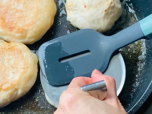 平底鍋熱鍋後倒入油，將包好的麵糰放入鍋中中小火煎至上色後翻面用湯杓將面糰壓一下繼續中小火慢慢煎熟即可。