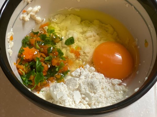 所有食材混在一起拌勻。
模具刷油，鋪上蒸籠紙，
撒適量芝麻粉，倒入拌勻的食材。