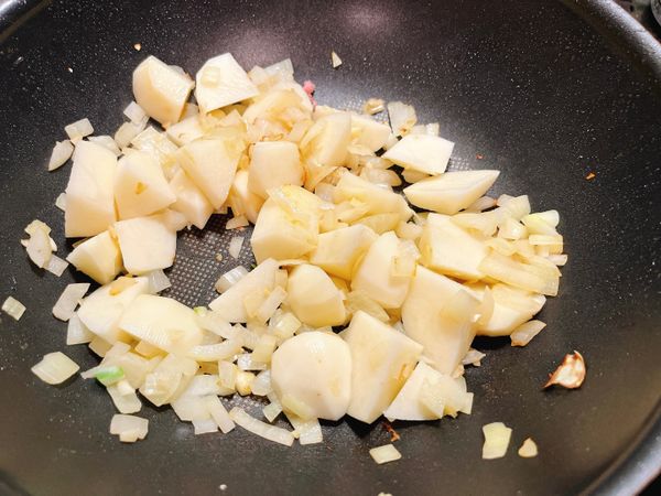 洋蔥碎、蒜頭先爆香炒至香味出來之後，加入馬鈴薯塊拌炒