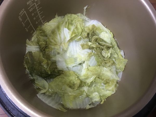 時間到後，打開鍋蓋，將白菜撈出，湯汁留在鍋裡，按下再加熱。