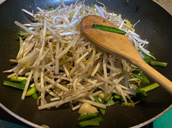 蒜頭跟韭菜炒出香味後丟入豆芽菜