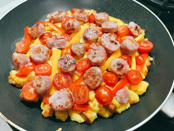 擠上番茄醬，放上香腸、甜椒和小番茄