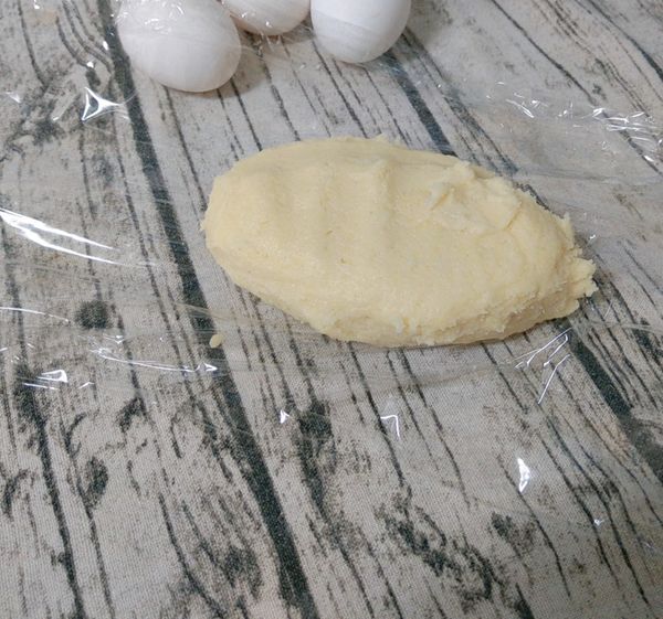 繼續加入全蛋液和香草糖，一樣利用刮刀切拌均勻，再用手掌心壓拌成糰，靜置20分鐘備用。