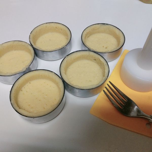 用叉子在蛋塔皮的底部插洞（防止烘烤時底部澎漲突起）。