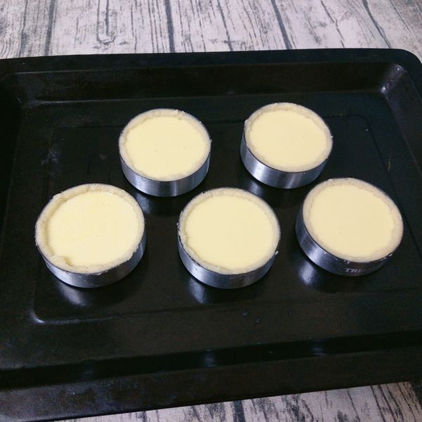 將蛋塔液倒入叉好洞洞的蛋塔皮上(注入約8分滿），放入已預熱的烤箱中烘烤。(200/190 10分鐘，190/190 20分鐘)。