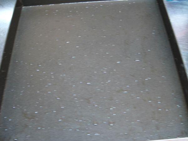 烤盤底部加一層薄薄的水，再鋪烤紙。這樣烤紙比較黏住定型。