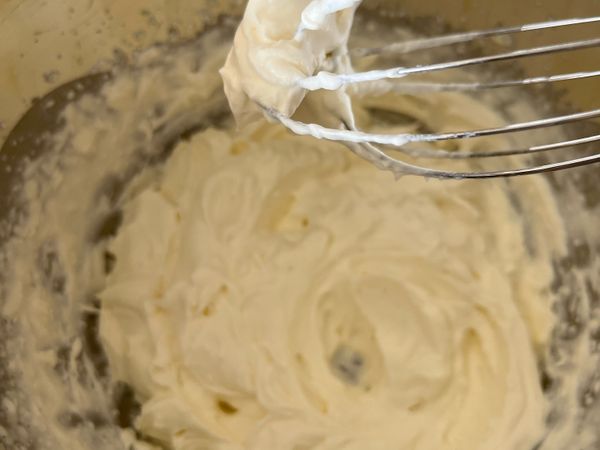 將作法1打至九分發（質地紮實，撈起時尖角硬挺的程度）。

加入希臘優格，攪拌拌勻。

若無希臘優格，可用水切優格代替。
水切優格作法：盆上架一個濾網，濾網上鋪一張廚房紙巾，接著放上一般市售優格200g，放置於冰箱冷藏一晚，瀝除水分。