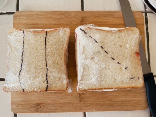 用保鮮膜緊緊包住三明治

先將吐司冷藏30分鐘靜置一下以便後續裁切。
冷藏後鮮奶油會再變硬一點，麵包也會吸收鮮奶油多餘的水分而變得濕軟，如此一來既好切，斷面也會很漂亮。

黑線為下刀切開處

若要做平行切三個長條，請在下刀處擺上草莓。