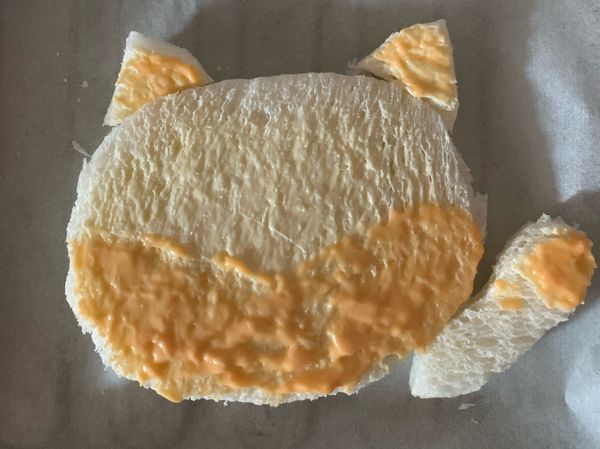 底部全部塗黃油，再把貓咪頭的下半，貓手掌和耳朵塗芝士醬（如圖）