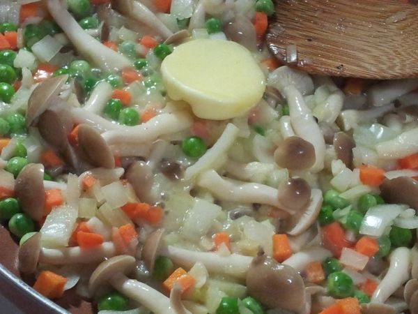 接著鴻喜菇.紅蘿蔔丁.青豆仁一起拌炒 再加一塊奶油