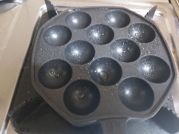 章魚燒鍋噴些油，倒入8分滿麵糊。