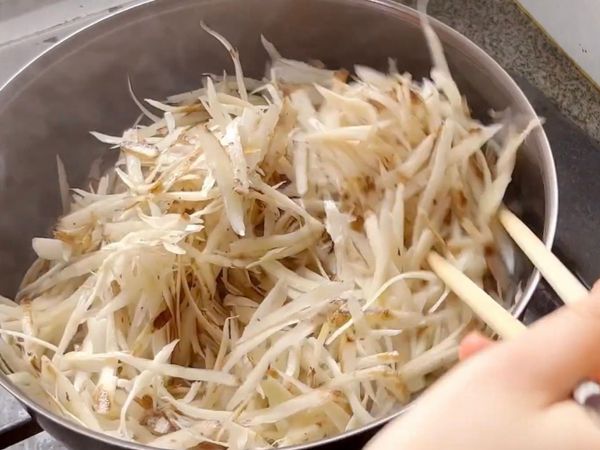 燒熱鍋、下少許油，倒入牛蒡絲，以中火將牛蒡絲炒香。