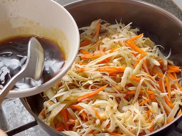 炒到牛蒡和甘筍絲變軟後倒入調味料，繼續炒勻並煮至汁收乾。