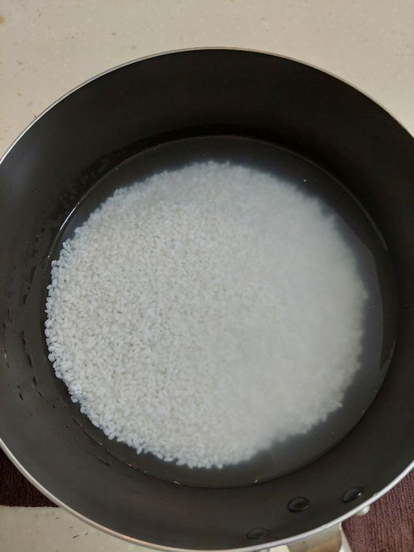 取一厚底小湯鍋，加入白米與所需的常溫水，開大火把水燒開(4~5分鐘)