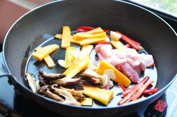 放入少許油熱鍋後，將辣椒、香菇、胡蘿蔔、蒜末、五花下鍋拌炒煸香